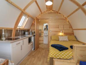 a small bedroom with a bed in a tiny house at Mischief in Harpham