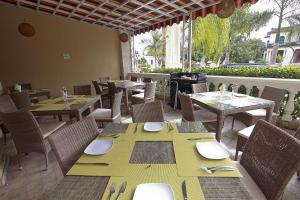 ein Restaurant mit Tischen und Stühlen und einem großen Fenster in der Unterkunft Wyndham Merida in Mérida