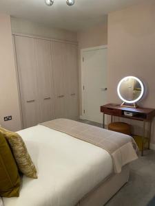 a bedroom with a bed and a table with a mirror at The Flat on Humber Street in Hull