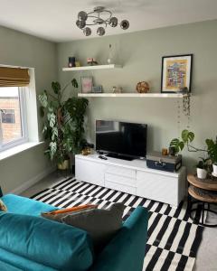 a living room with a blue couch and a tv at The Flat on Humber Street in Hull
