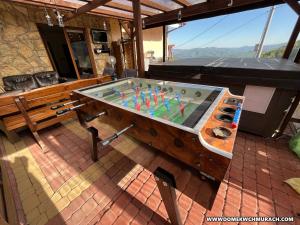 a pool table on a patio with a bench at Domek w Chmurach in Kicznia
