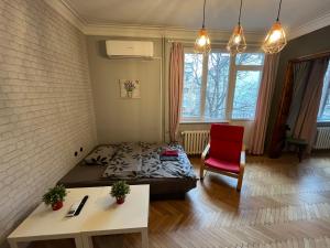 a bedroom with a bed and a red chair at Your Space in Sofia in Sofia