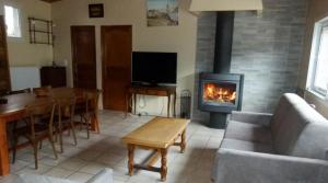 a living room with a fireplace and a table and a couch at La Source in Condamine-Châtelard
