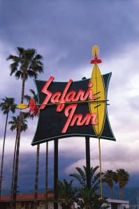 a sign for a zahanna inn with palm trees at Safari Inn, a Coast Hotel in Burbank