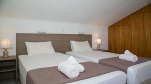 2 camas en una habitación de hotel con toallas en Panorama View en Agios Stefanos