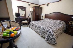 Un dormitorio con una cama y una mesa con fruta. en Hotel Carol en Constanza
