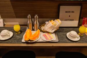 a tray with oranges and other foods on a table at Uno Prime Motel - Av Aricanduva in São Paulo