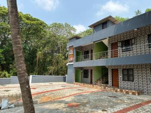 a building with a palm tree in front of it at ISHRA SERVICE APARTMENTS in Dharmastala