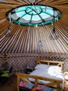 a room with a bed and a window in a yurt at 'Villager' the Yurt at Pentref Luxury Camping in Penuwch