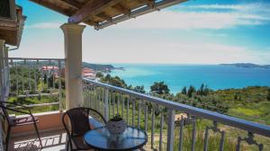 a balcony with a table and chairs and the ocean at Panorama View in Agios Stefanos