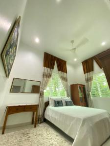 1 dormitorio con 1 cama, escritorio y ventanas en VILLA PERMATA IBU en Jeram