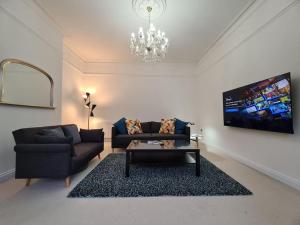a living room with a couch and a table at Large Modern Victorian Apartment in Ventnor