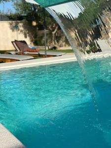una piscina azul con una fuente de agua en Villa Stalla en Kastel Stari