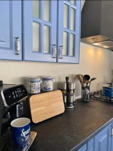 a kitchen counter with blue cabinets and a wooden cutting board at Villa Stalla in Kastel Stari +19 photos