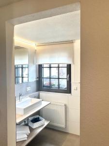 baño blanco con lavabo y ventana en Hotel Ochsen en Friesenheim