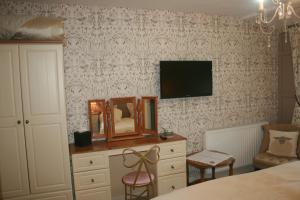een slaapkamer met een bed, een spiegel en een dressoir bij School House Cottage B&B and tea garden in Hawkshead