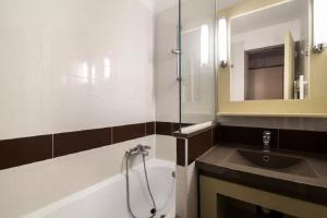 La salle de bains est pourvue d'une baignoire, d'un lavabo et d'une douche. dans l'établissement Residence Le Village de Cap Esterel - maeva Home, à Agay