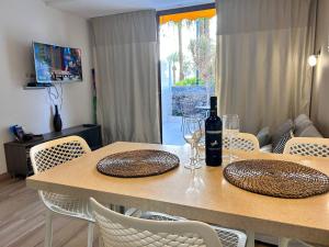 una mesa de comedor con sillas y copas de vino. en Apartment Virginia en Playa de las Americas