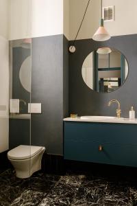 W łazience znajduje się toaleta, umywalka i lustro. w obiekcie Aparthotel Nowy Świat 28 w Warszawie