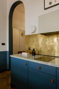 kuchnia z niebieskimi szafkami i blatem w obiekcie Aparthotel Nowy Świat 28 w Warszawie
