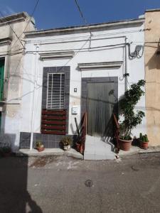 un edificio blanco con una puerta y algunas plantas en Da Nonna Lucia, en Roccaforzata
