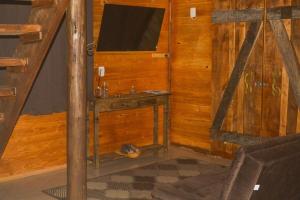 Kleines Zimmer mit einem Tisch und einem TV. in der Unterkunft RECANTO DO SINALEIRO GRAMADO in Gramado