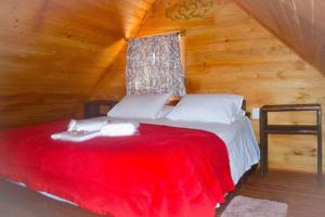 1 dormitorio con cama roja en el ático en RECANTO DO SINALEIRO GRAMADO, en Gramado