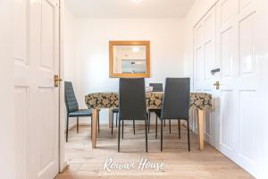 uma sala de jantar com uma mesa com cadeiras e um espelho em Rowan Serviced Accommodation em Lowton