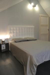 um quarto com uma cama grande e uma cabeceira branca em Gite de Charme em Villeneuve-sur-Auvers