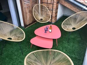 a group of chairs and a table with a red table at Le 6 Bis by Les Cailloux Dorés in Uzès