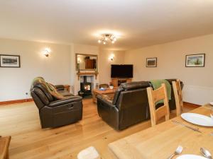 a living room with two leather chairs and a table at Ash Gill Cottage in Coniston