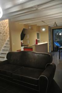 a living room with a couch and a kitchen at Gite de Charme in Villeneuve-sur-Auvers