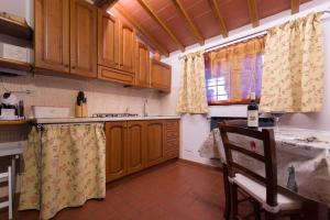 a kitchen with wooden cabinets and a table and a window at Montechiari In Chianti in Greve in Chianti
