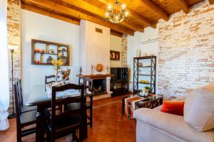 salon ze stołem i ceglaną ścianą w obiekcie vll Vivienda rural a las puertas de Doñana w mieście Villamanrique de la Condesa