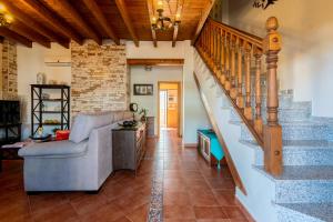 sala de estar con sofá y escalera en vll Vivienda rural a las puertas de Doñana, en Villamanrique de la Condesa