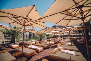 een rij tafels met parasols op een patio bij Seven Visions Resort and Places, the Dvin in Jerevan