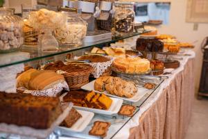 een buffet met verschillende soorten gebak en zoete deegwaren bij Pousada Portal do Vigolo in Nova Trento