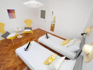 a room with two beds and chairs and a table at Downtown apartment Tango in Zadar