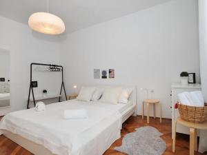 a white bedroom with a bed and a mirror at Downtown apartment Tango in Zadar