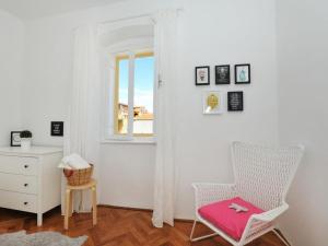 a white room with a chair and a window at Downtown apartment Tango in Zadar +2 photos
