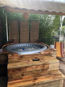 una gran bañera de hidromasaje en la parte superior de una terraza de madera en Chez Vincent et Myriam gîte de charme, en Aussonne