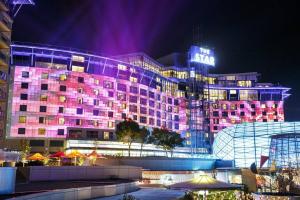 a hotel building with a lit up facade at night at Luxury 2 bed short walk Sydney Convention Centre in Sydney