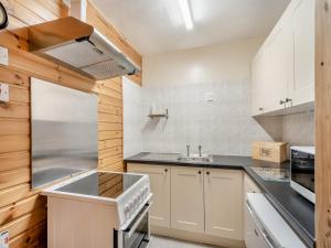 eine Küche mit weißen Schränken und einem Waschbecken in der Unterkunft Harness Room - 15454 in Cladich