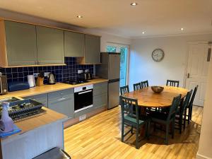 a kitchen with a wooden table and a dining room at Southover Beach in Woolacombe