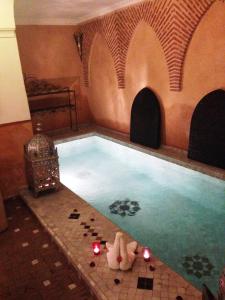 a swimming pool with candles in a room at Riad Bjoujna in Marrakesh