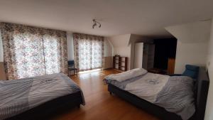 a bedroom with two beds and large windows at Villa Duinberg R-002 in Koksijde