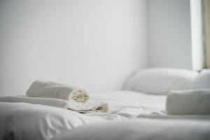 a white bed with white towels on it at JM Rooms Lubicz II in Krakow