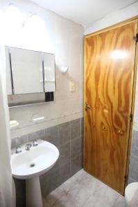 a bathroom with a sink and a wooden door at La Casa de Alicia in Tupungato