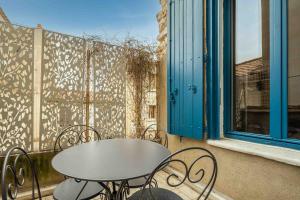 una mesa y sillas en un balcón con ventana en Le Solarium - Terrasse - Climatisation en Narbona