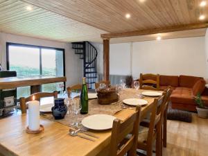 a dining room with a wooden table with wine glasses at Gîte Les Ebeteux in Fraize